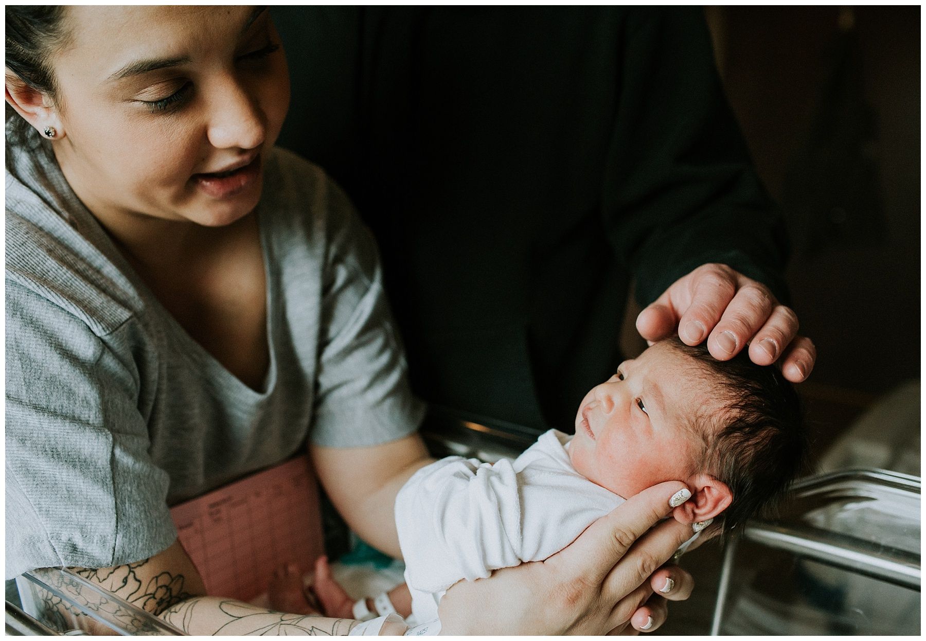 A woman is holding a newborn baby in her arms in a hospital room.