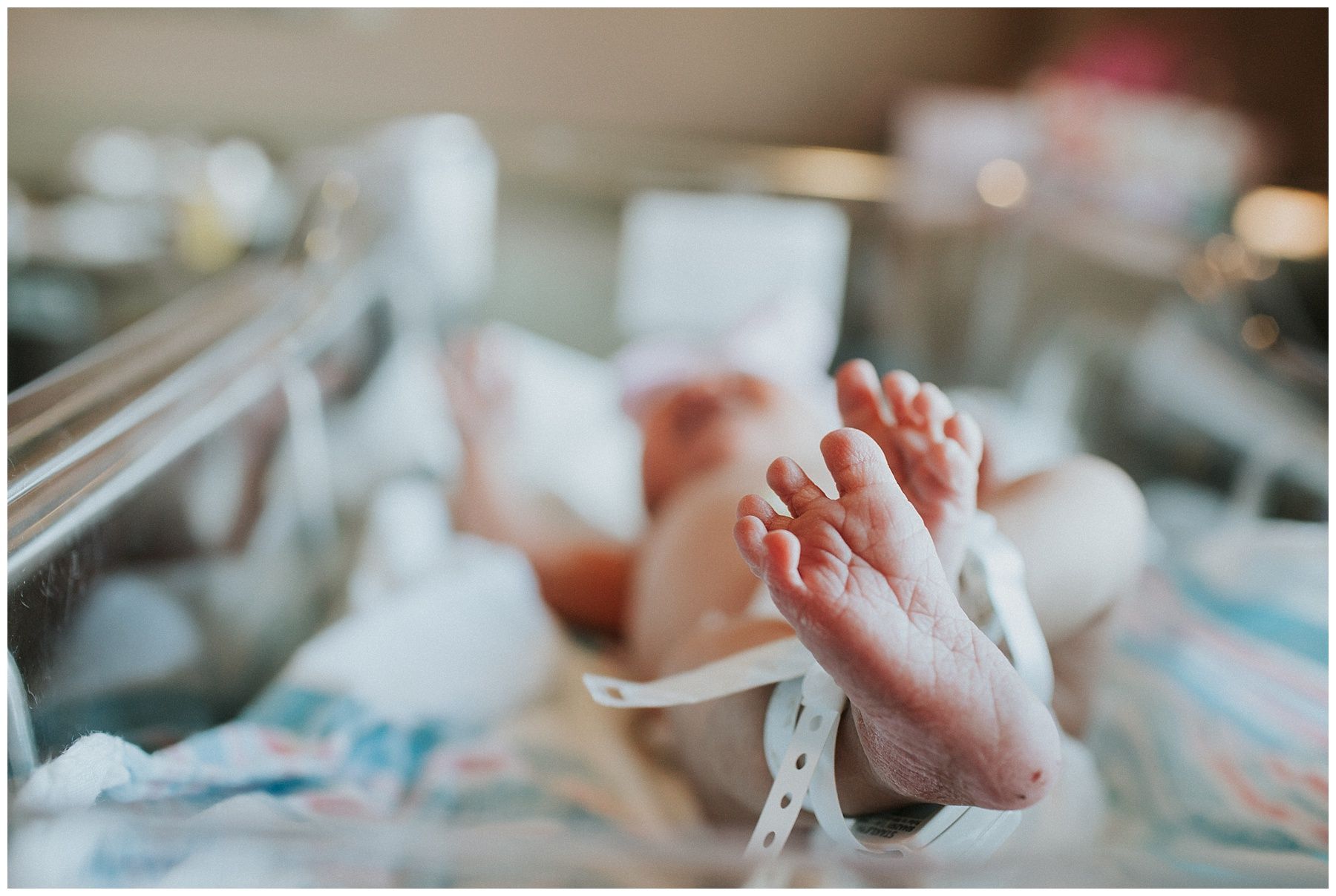 A close up of a baby 's feet in a hospital crib.