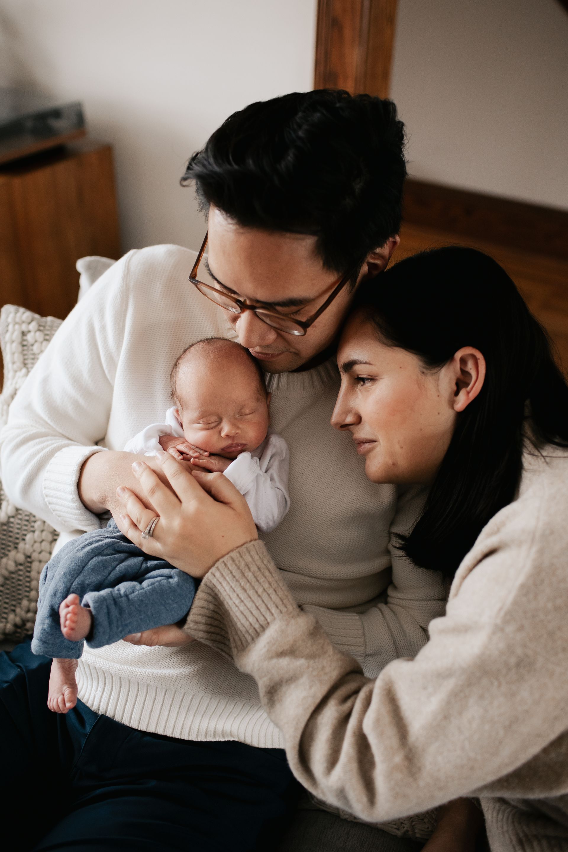A man and woman are holding a newborn baby in their arms.