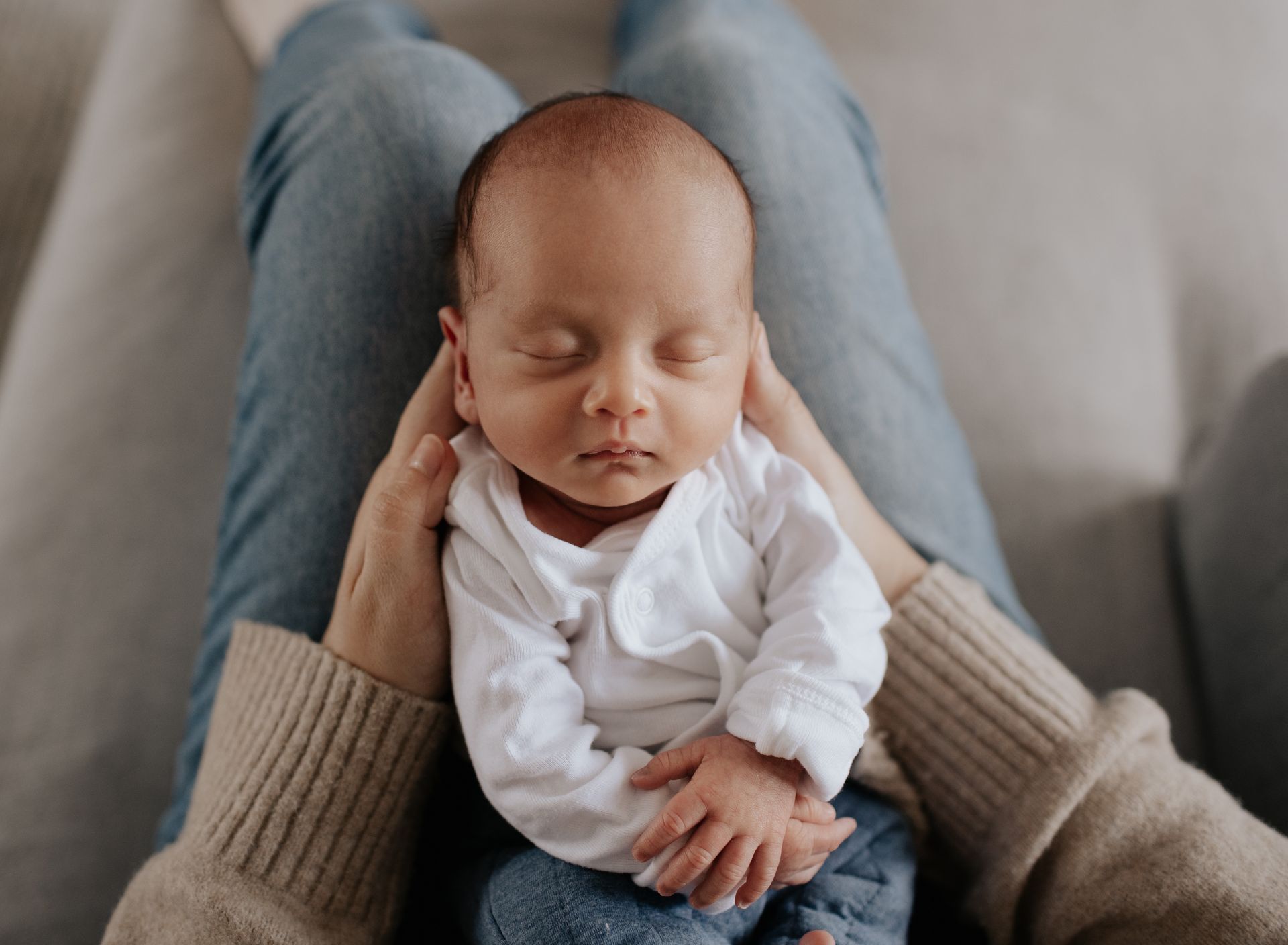 A woman is holding a newborn baby in her arms.