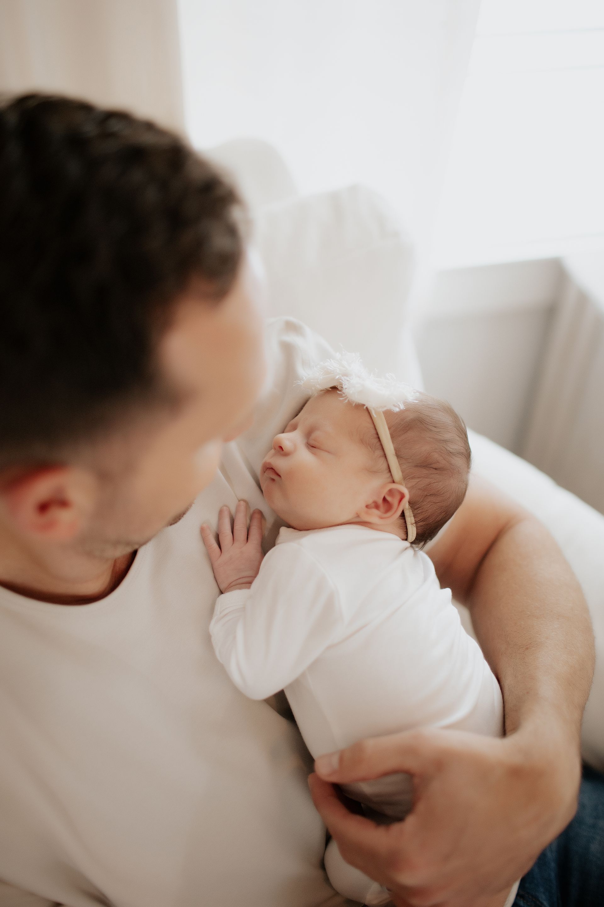 A man is holding a newborn baby in his arms.
