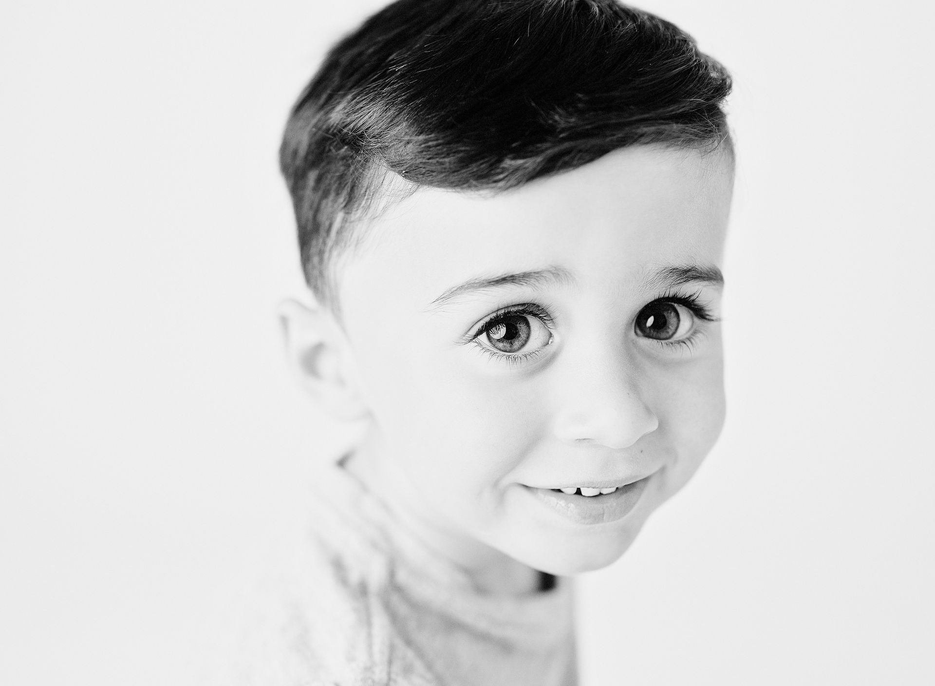 Young child with dark hair and a light smile.