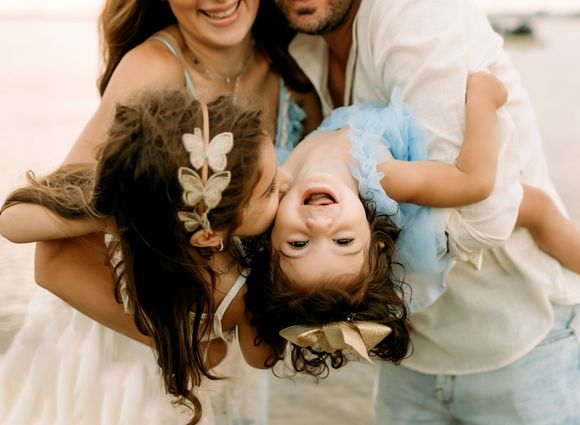 A family is posing for a picture on the beach.