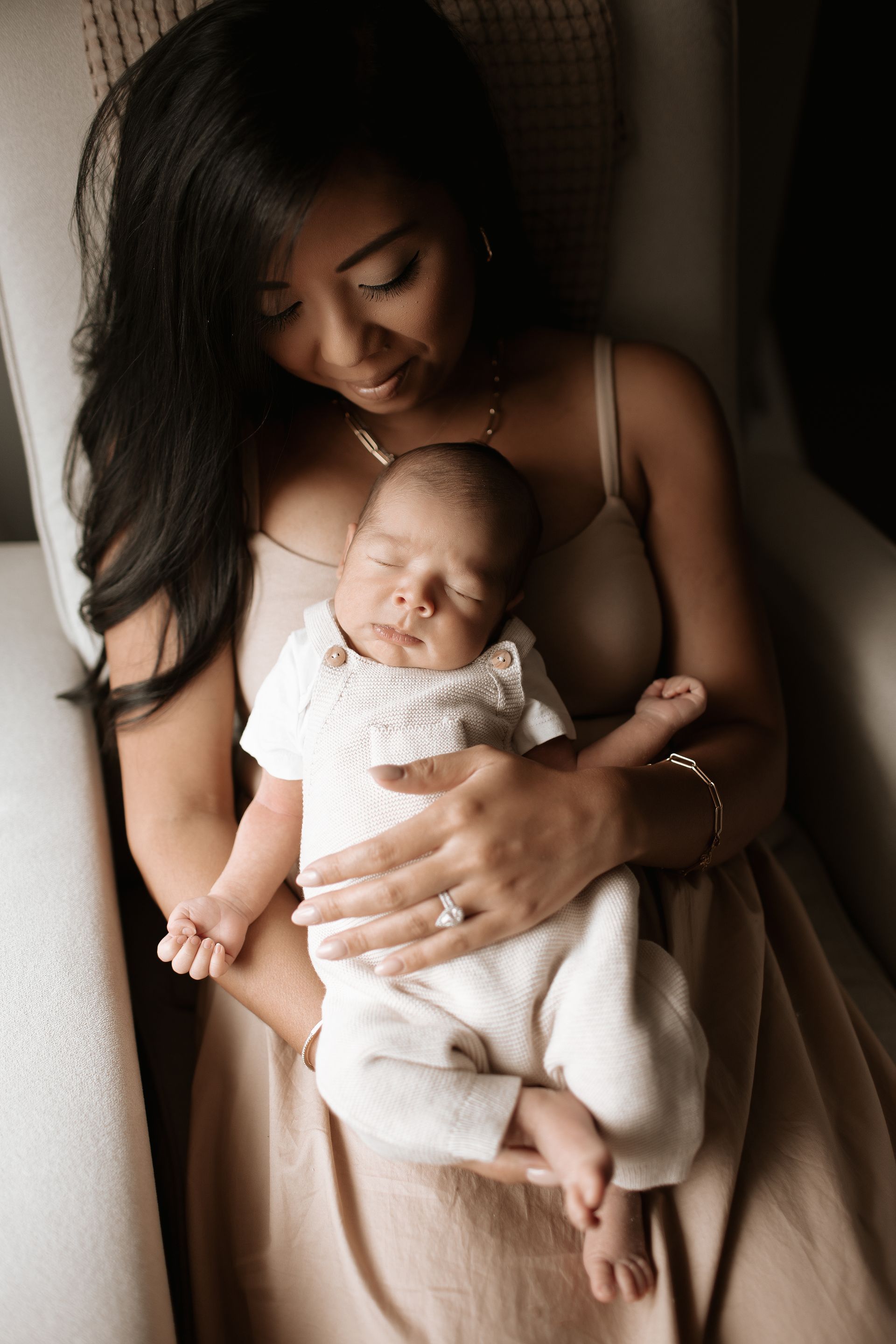 A woman is holding a newborn baby in her arms.