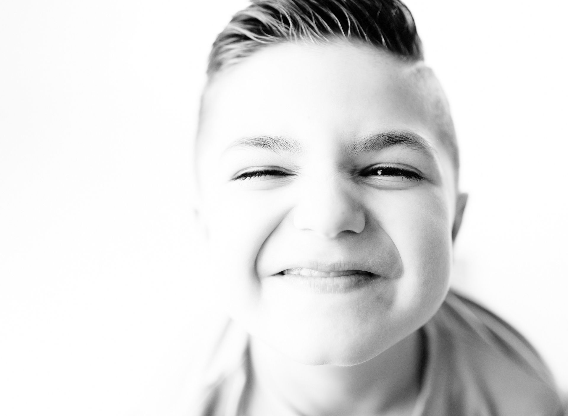 Smiling person with short, slicked-back hair, in black and white.