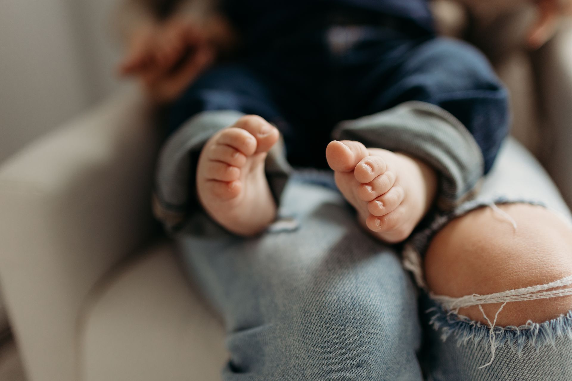 A close up of a baby 's feet sitting on a person 's lap.