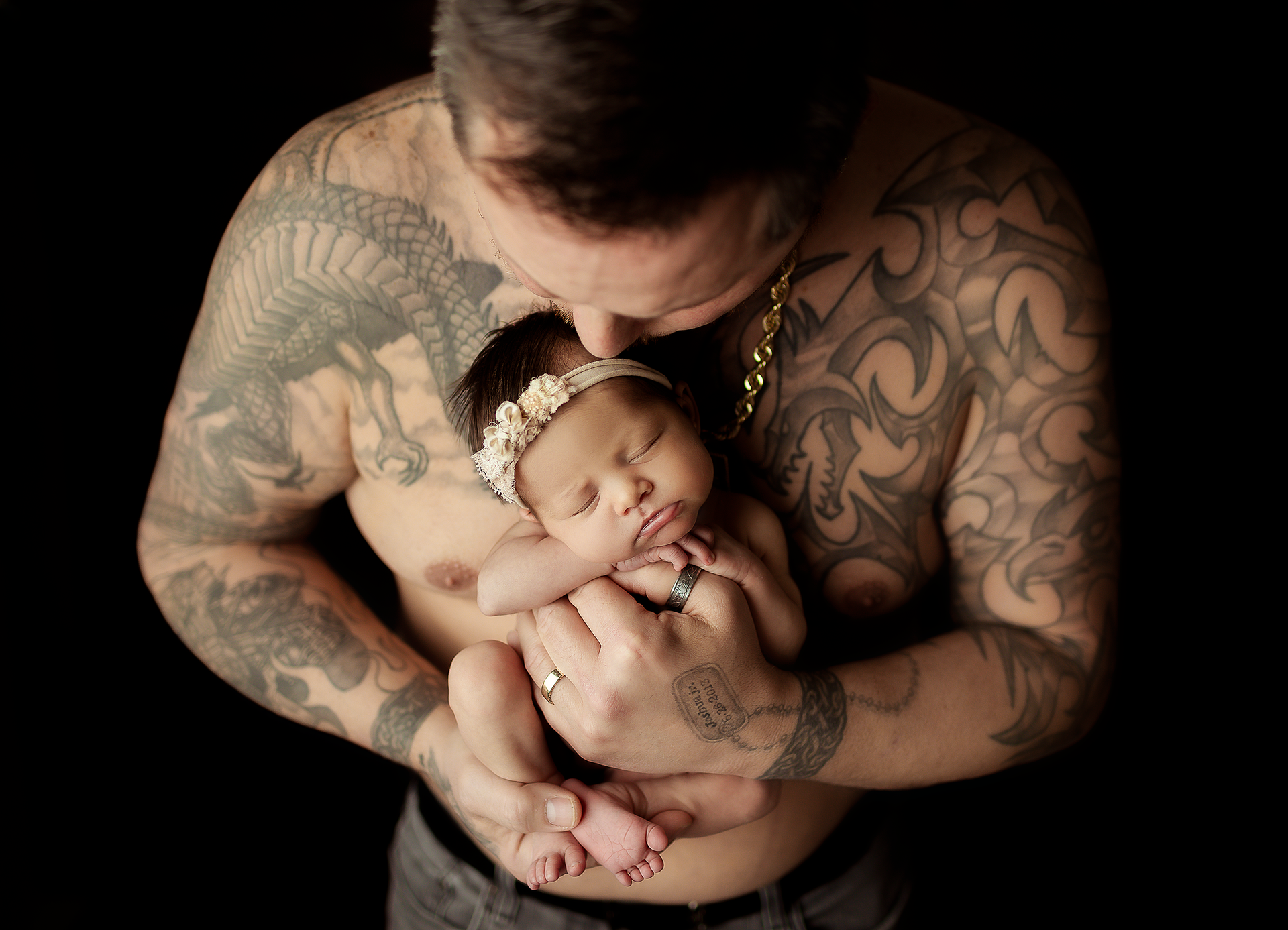 Dad with tattoos hold baby girl for a photo