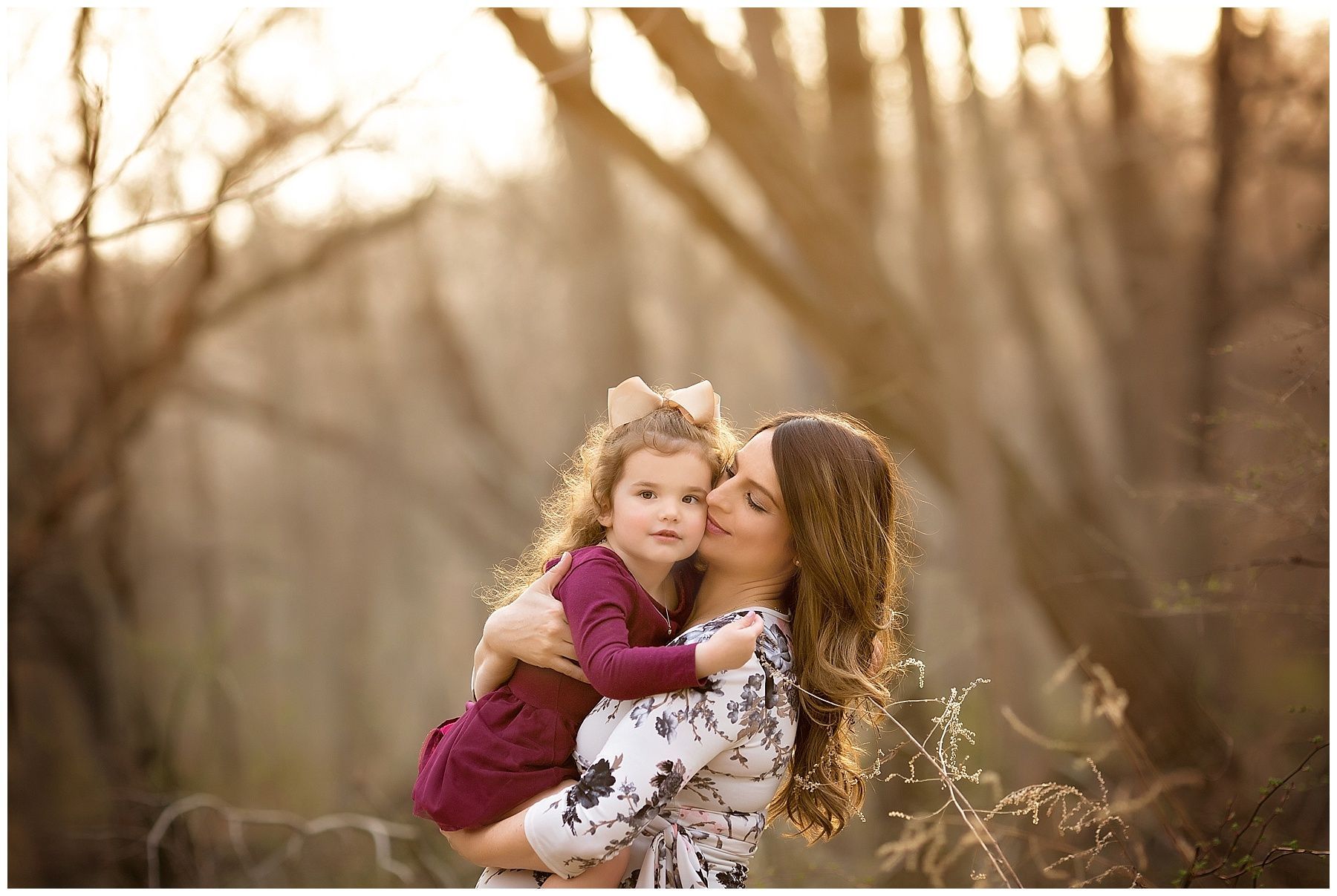 A woman is holding a little girl in her arms in a field.