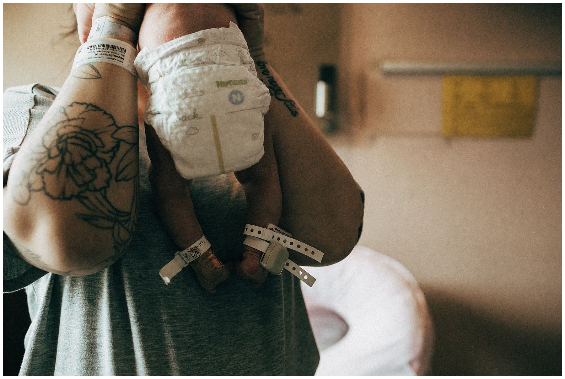 A woman is holding a baby in her arms in a hospital room.