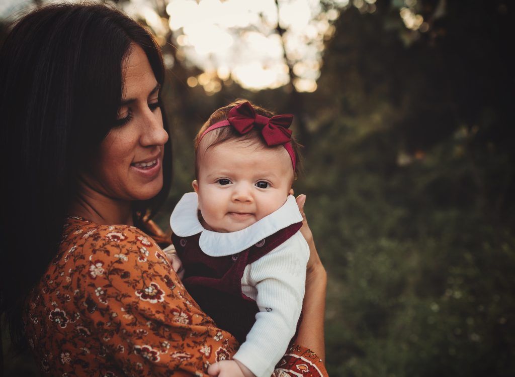 A woman is holding a baby in her arms.