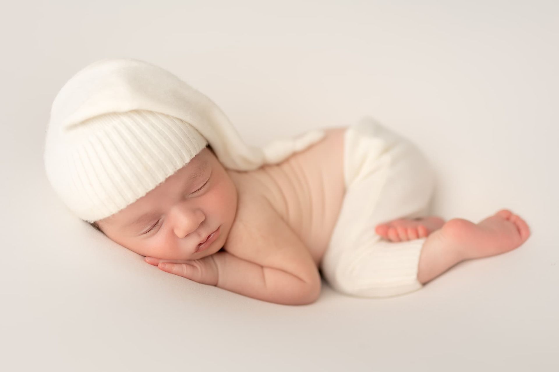 sleeping newborn baby wearing knit hat during Bergen County NJ newborn photography session