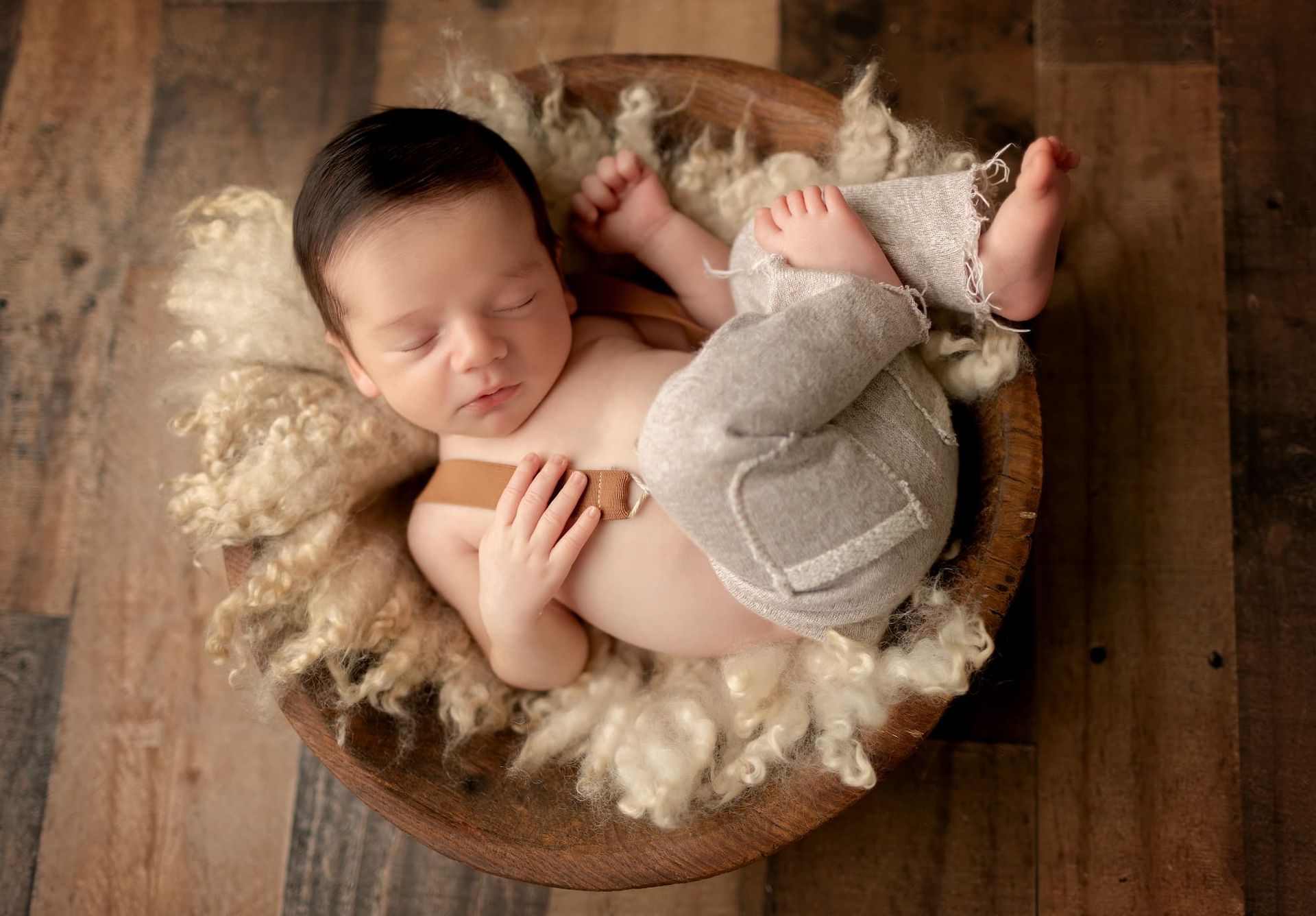 sleeping newborn baby posed in a wooden bowl during a Bergen County NJ newborn photography session