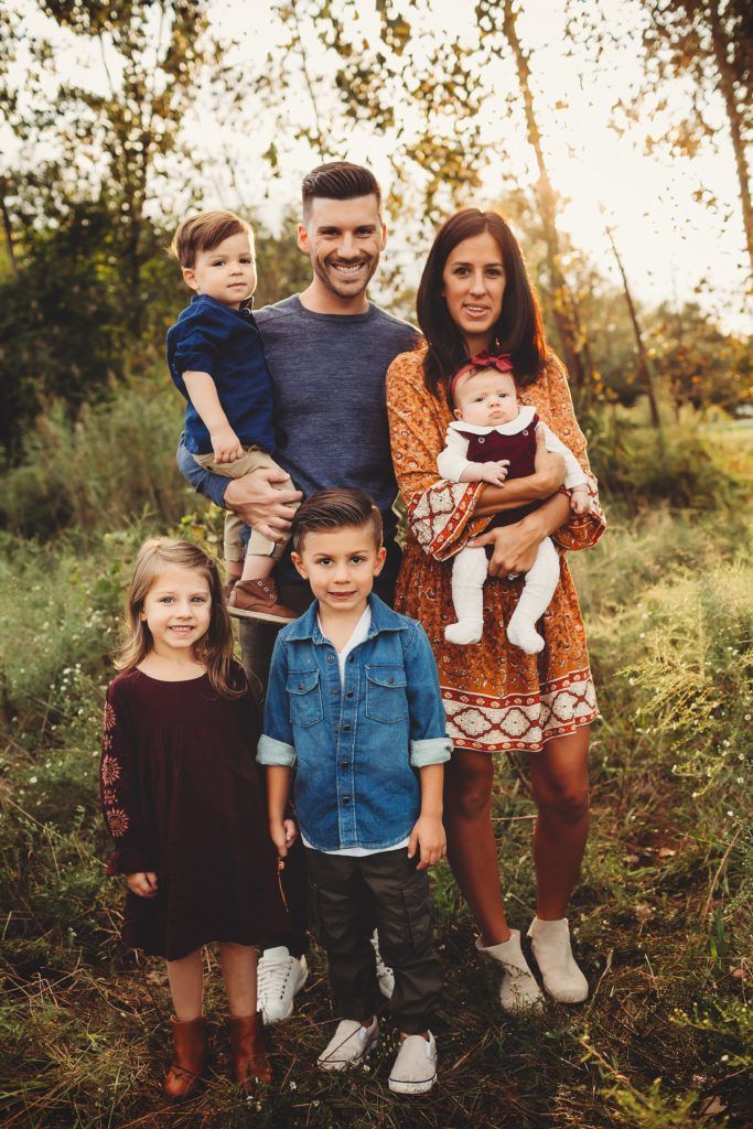 A family is posing for a picture in a field.