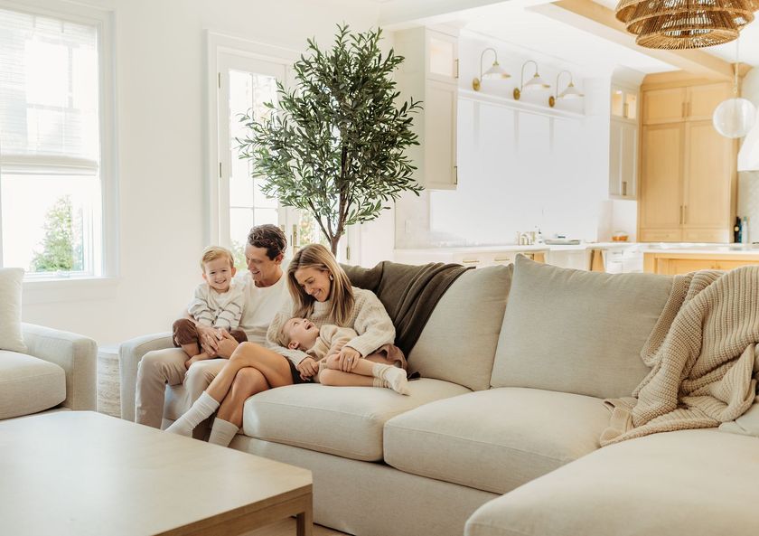 A family is sitting on a couch in a living room.
