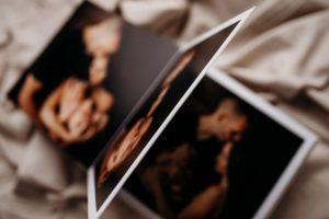 A couple of pictures of a woman and a baby are sitting on a bed.