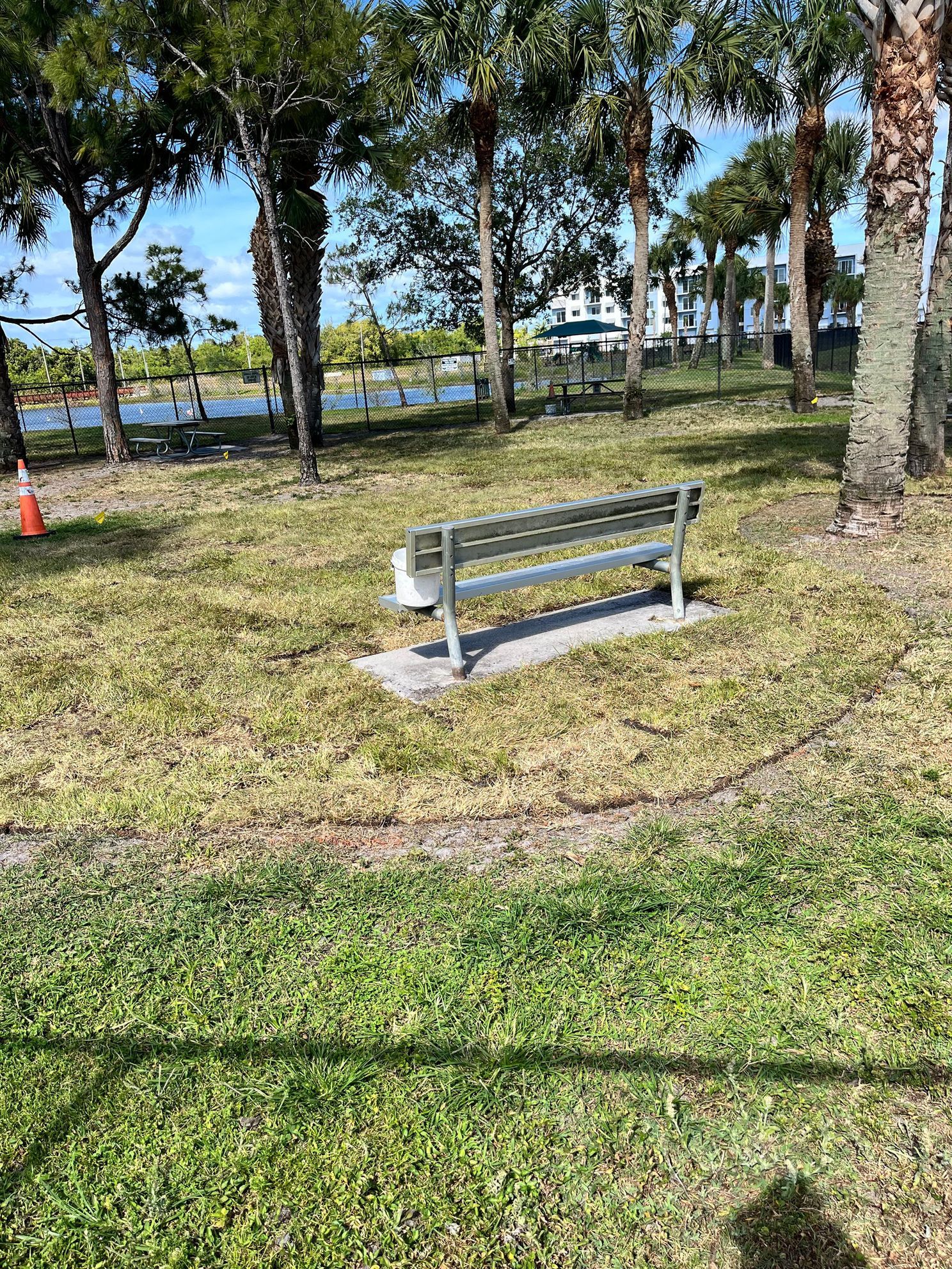 A park bench is sitting in the middle of a grassy field.