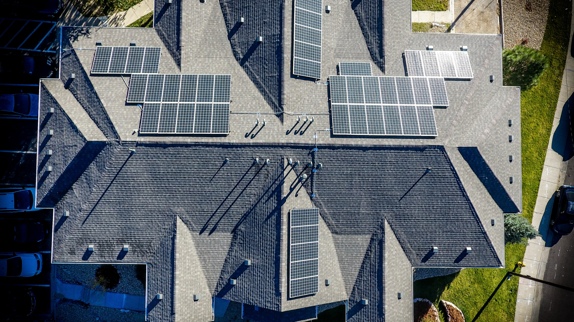 An aerial view of a house with solar panels on the roof.