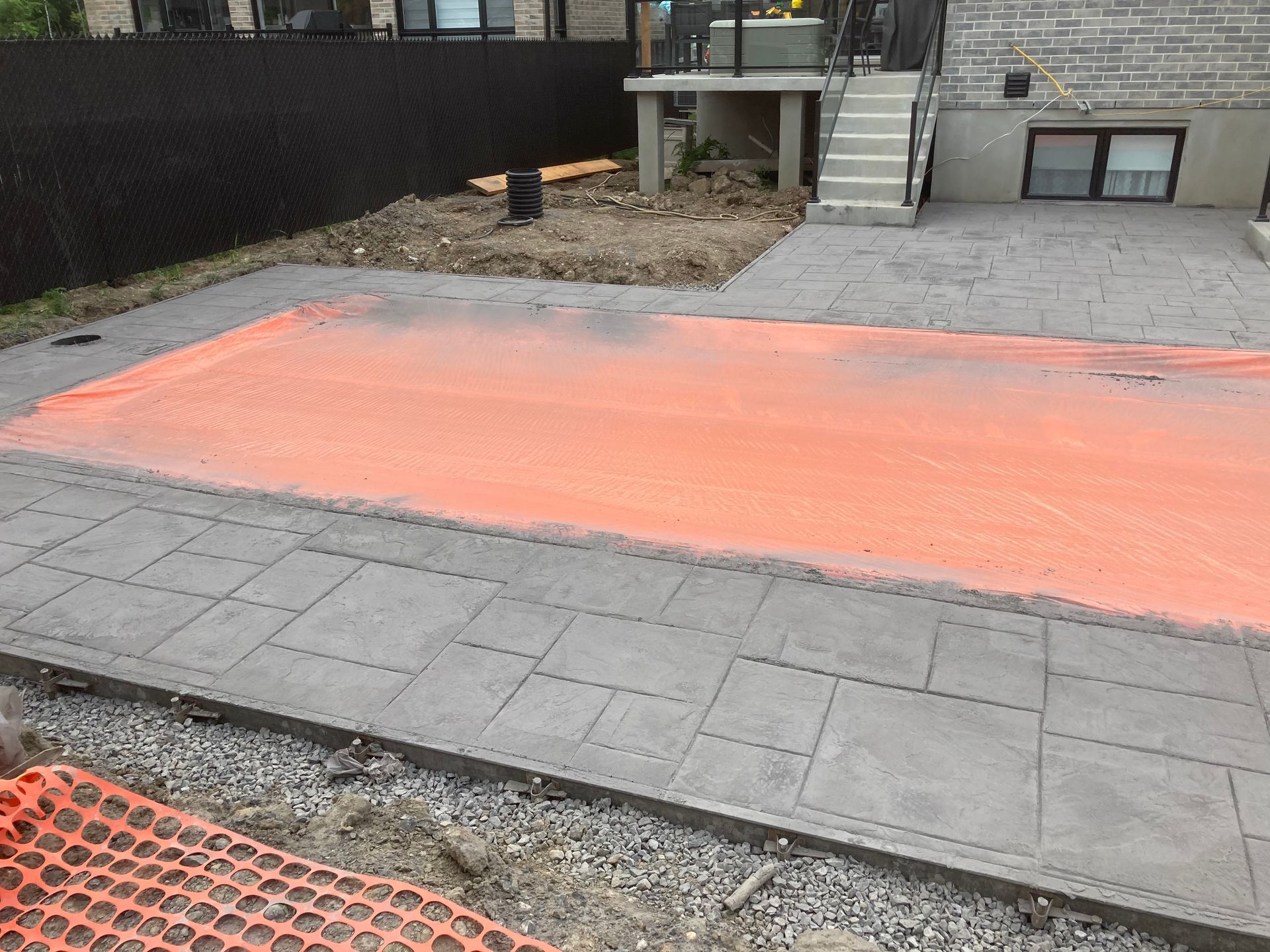 Une passerelle en béton est en cours de construction devant une maison.