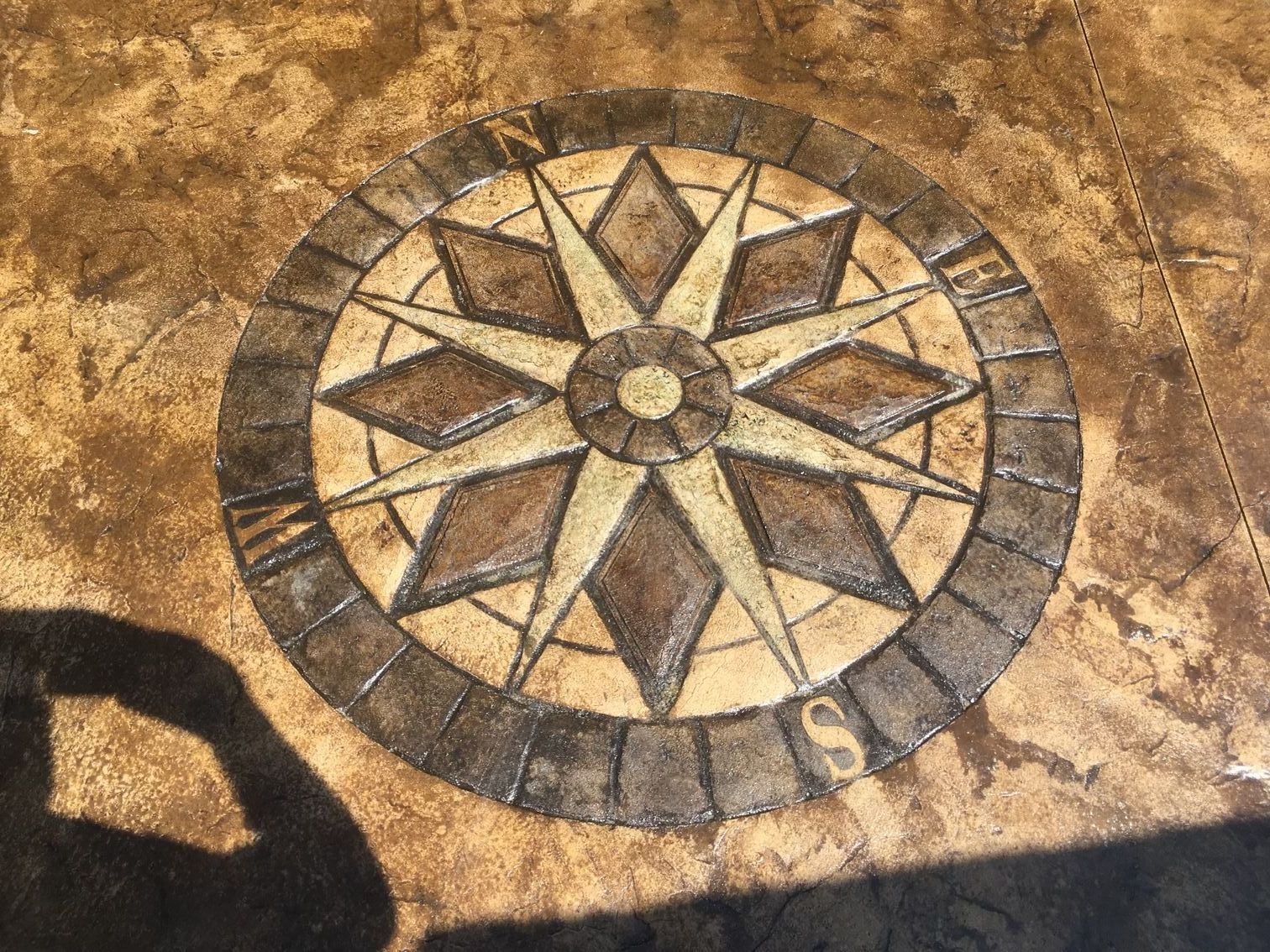 Une rose des vents est peinte sur une surface en béton