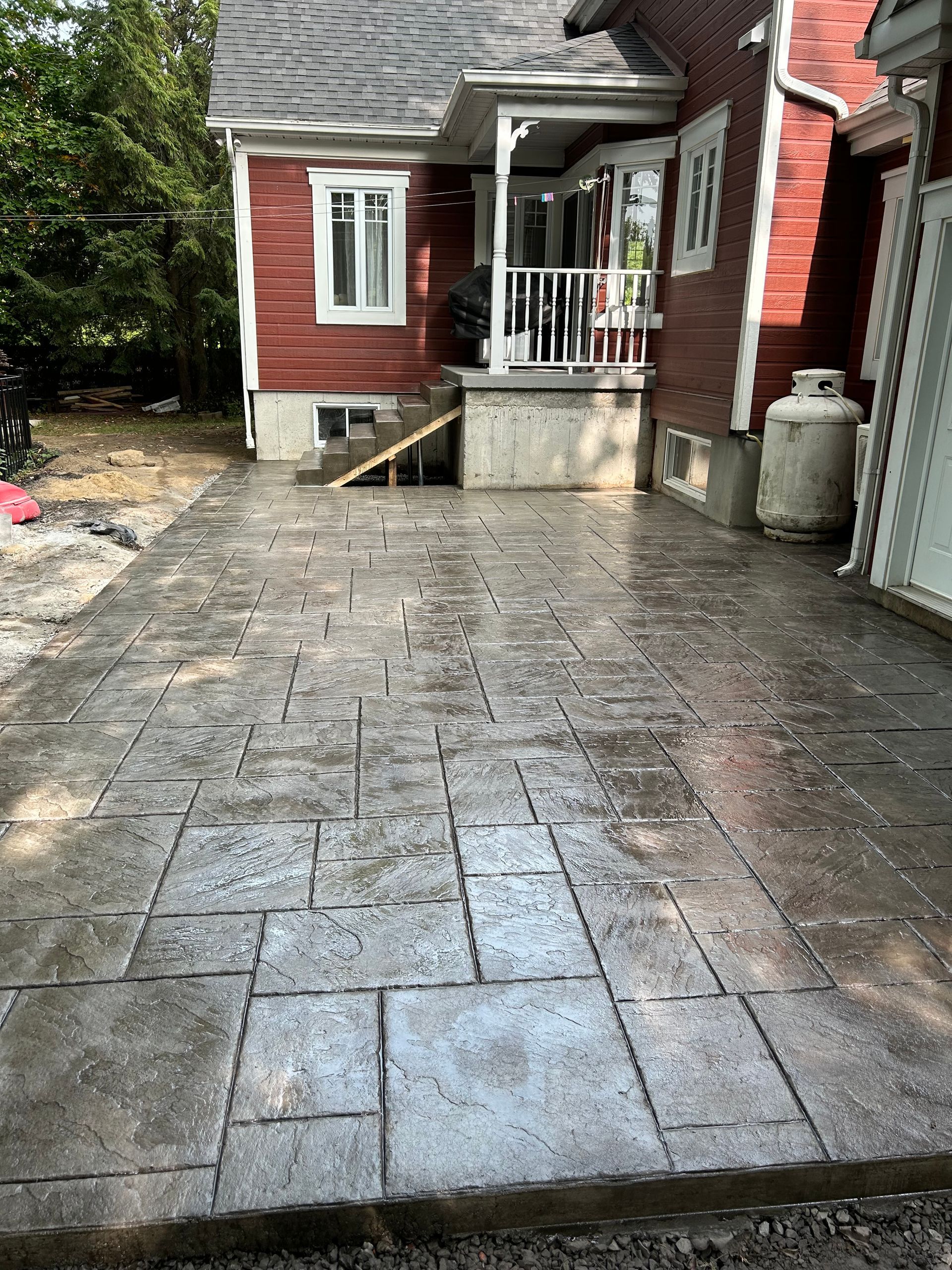 Une maison rouge avec un patio devant.