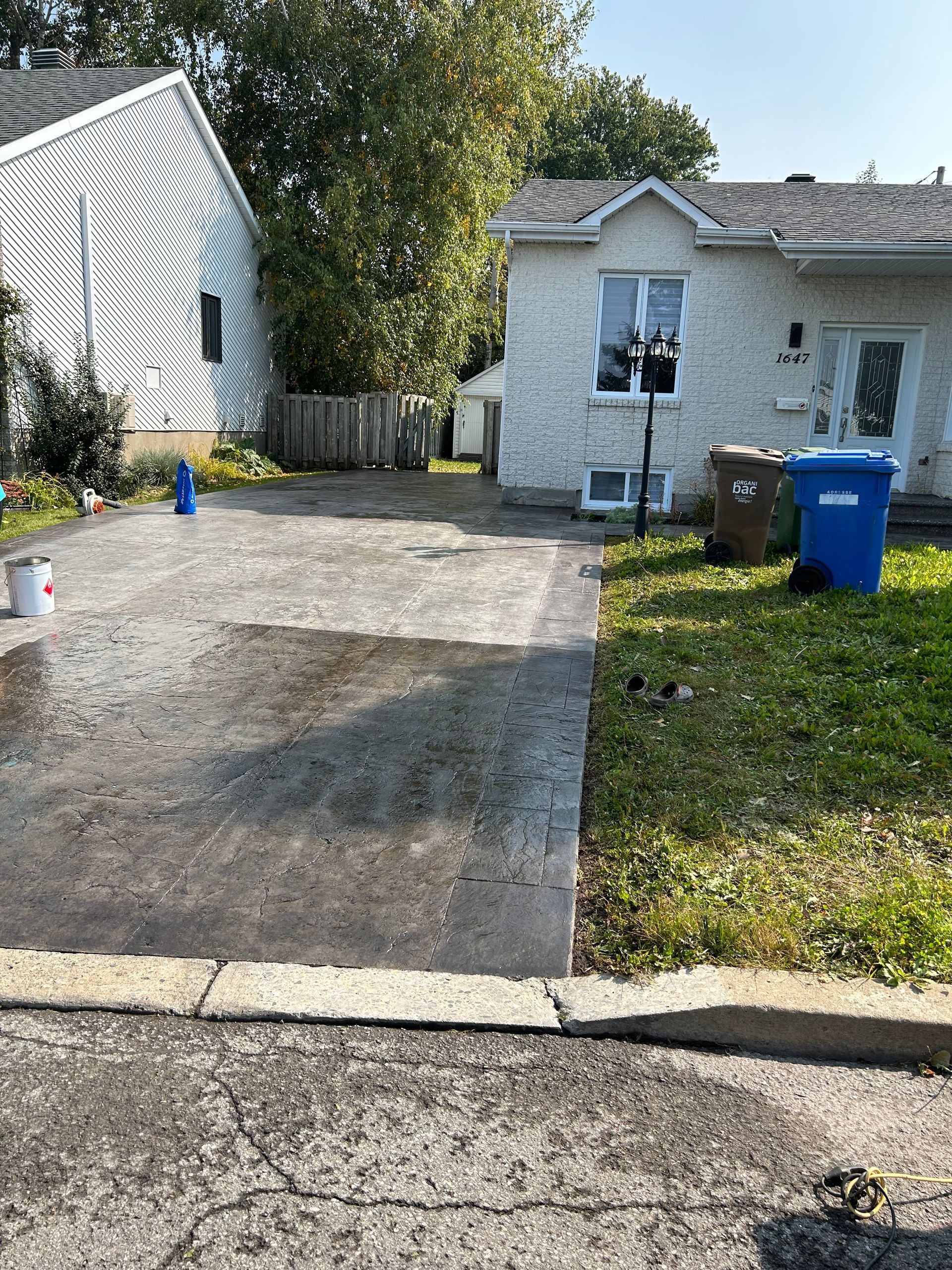 Il y a une allée en béton devant une maison.