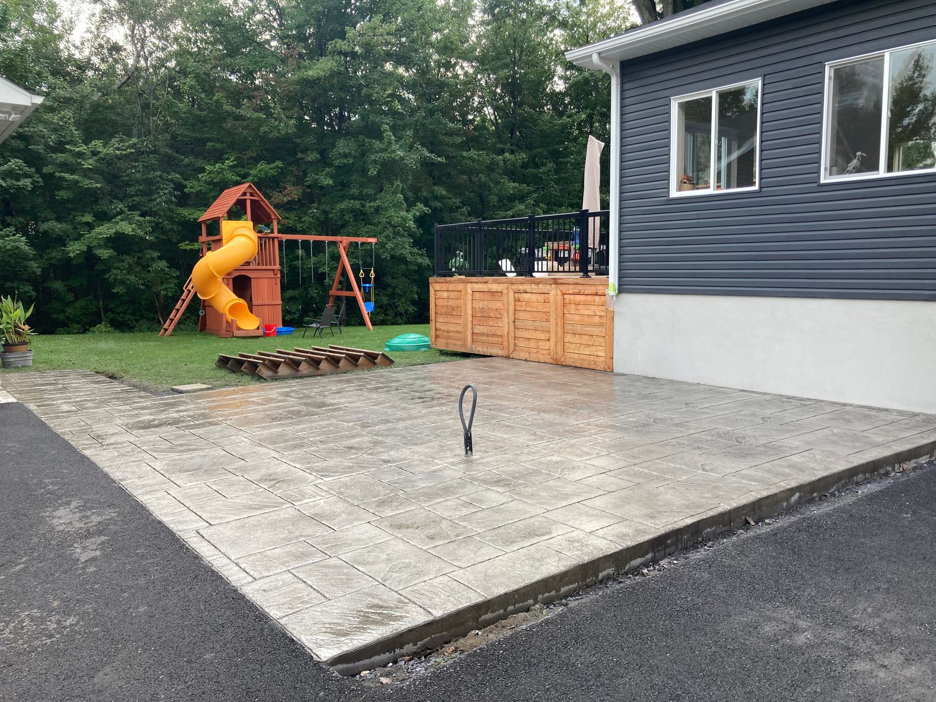 Il y a une aire de jeux dans l'arrière-cour d'une maison.