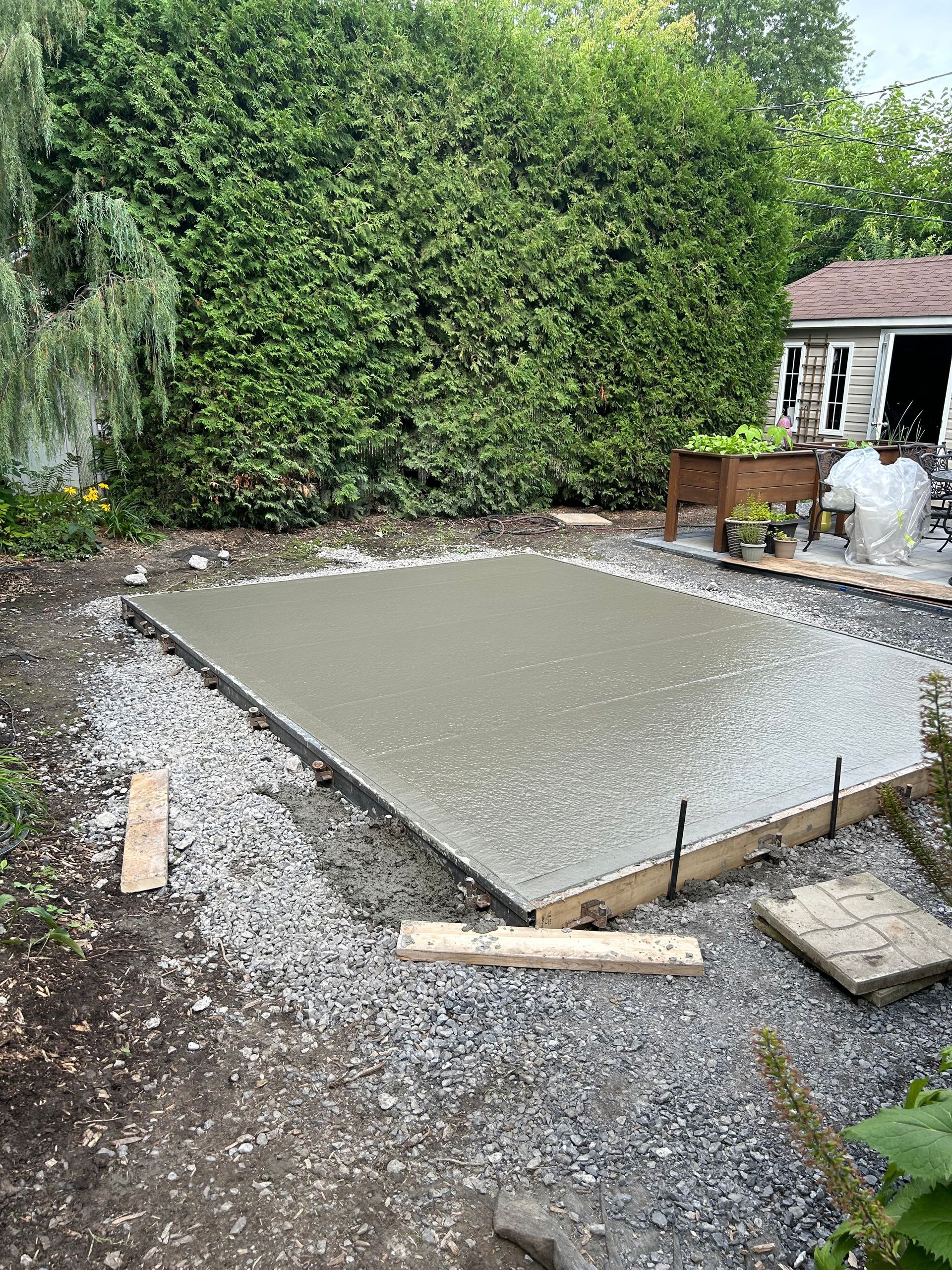 Une dalle de béton est en cours de construction dans une cour arrière.