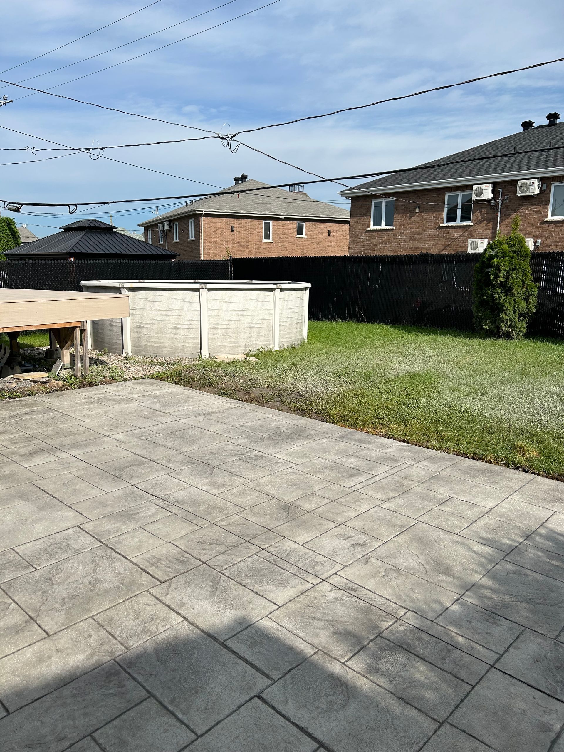 Une cour arrière avec une piscine et une maison en brique en arrière-plan