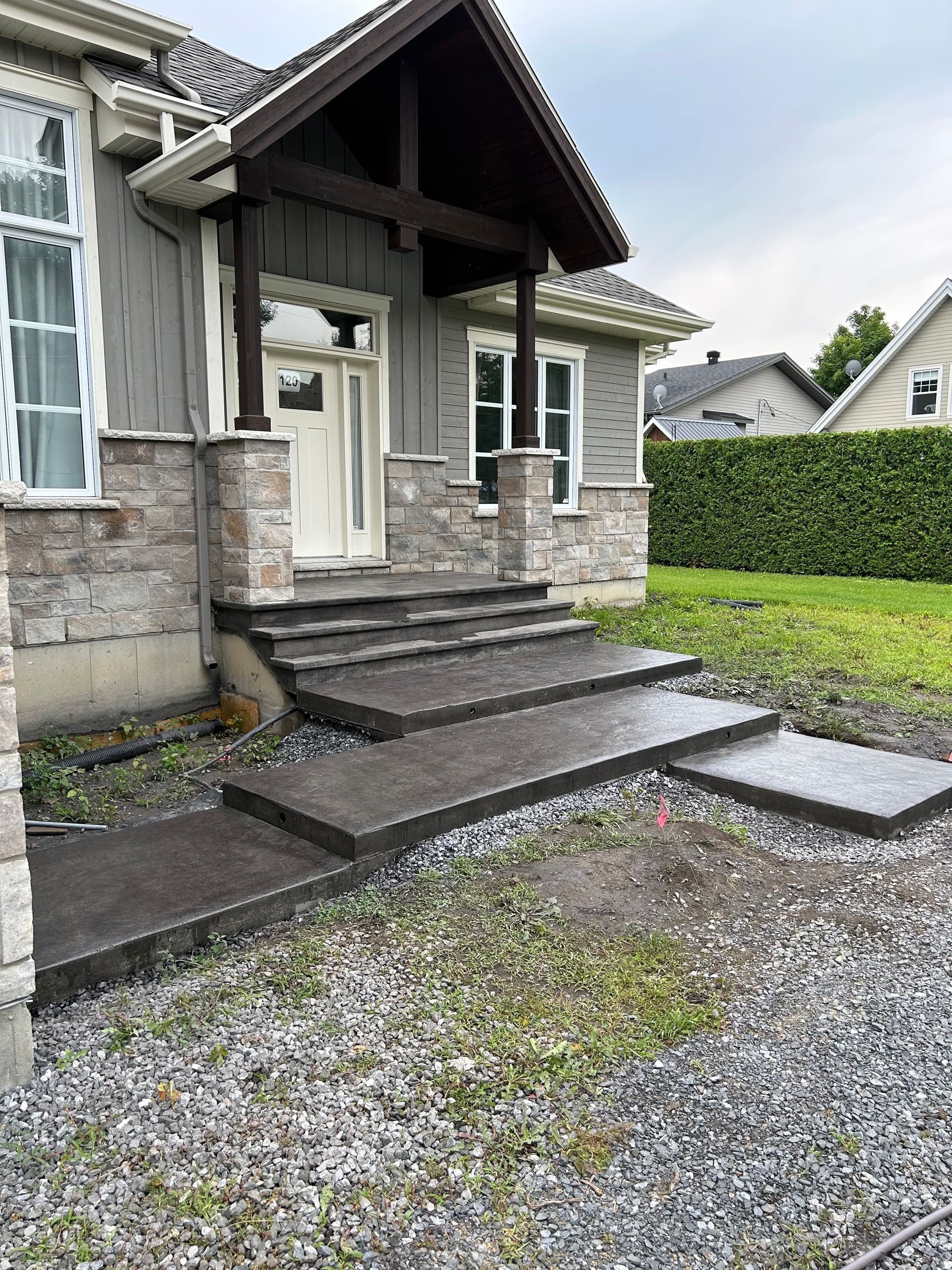 Une maison avec des marches en béton menant à la porte d'entrée.
