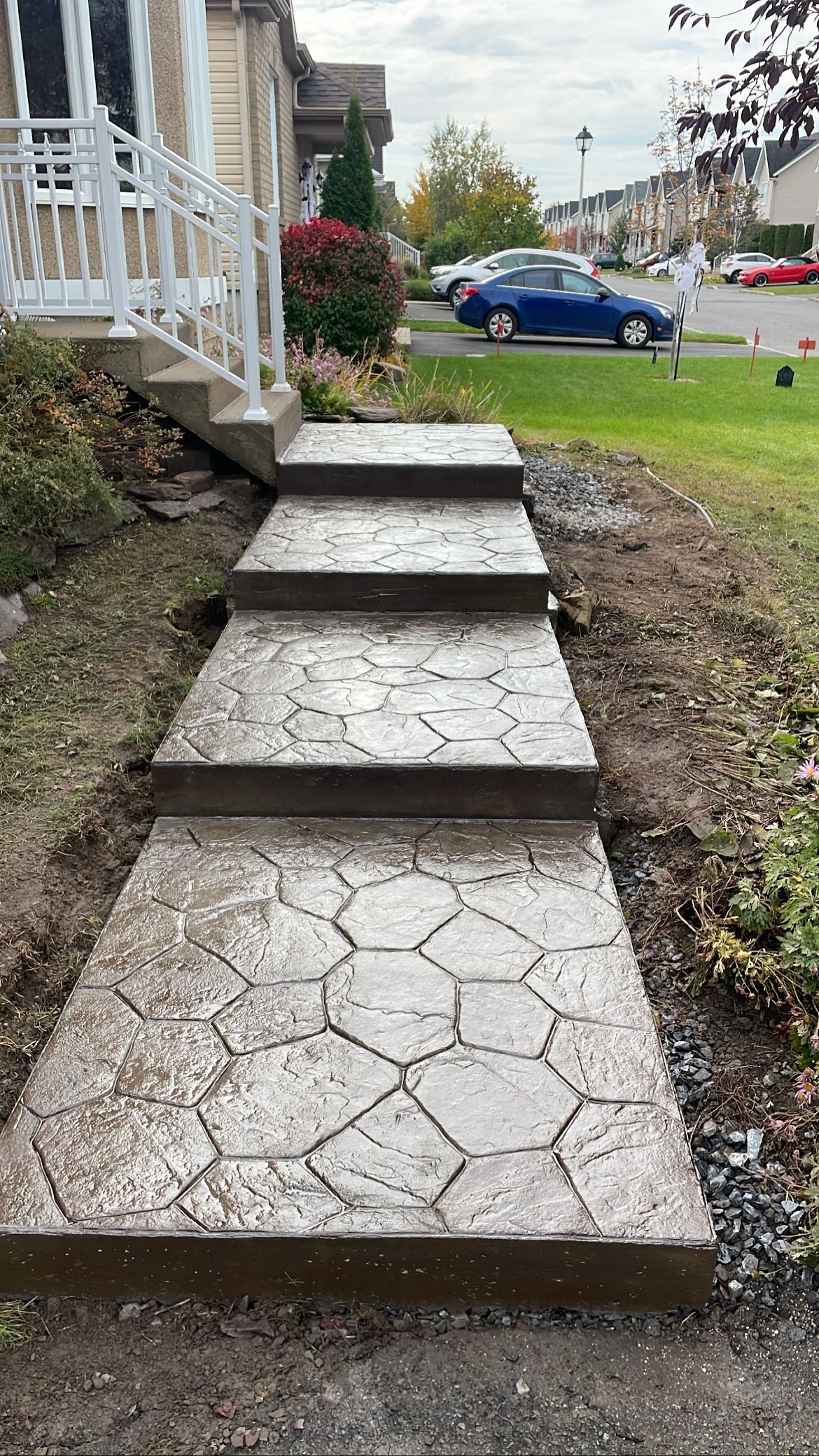 Une allée en béton avec des marches menant à une maison.