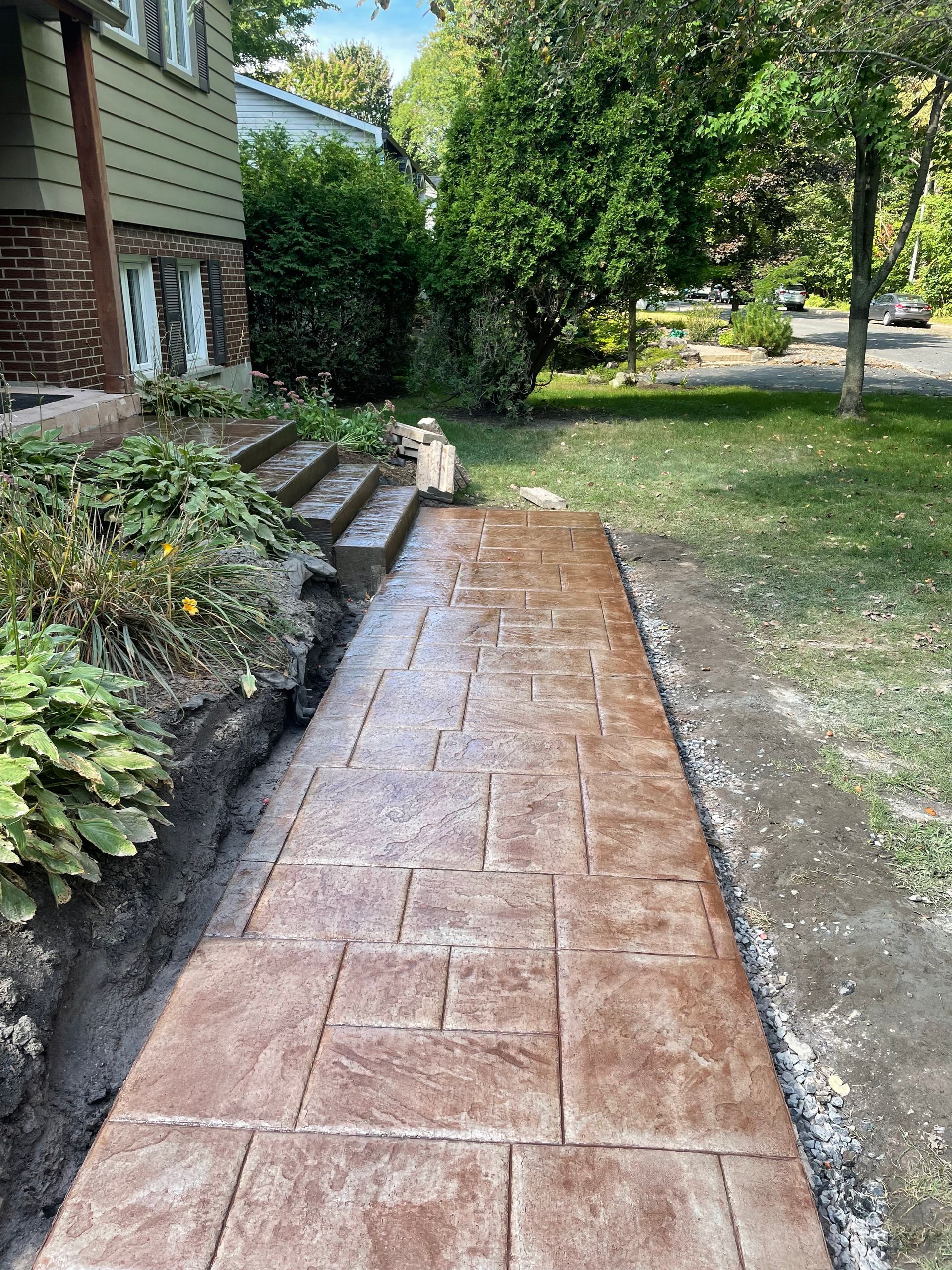 Une passerelle en béton est en cours de construction devant une maison.