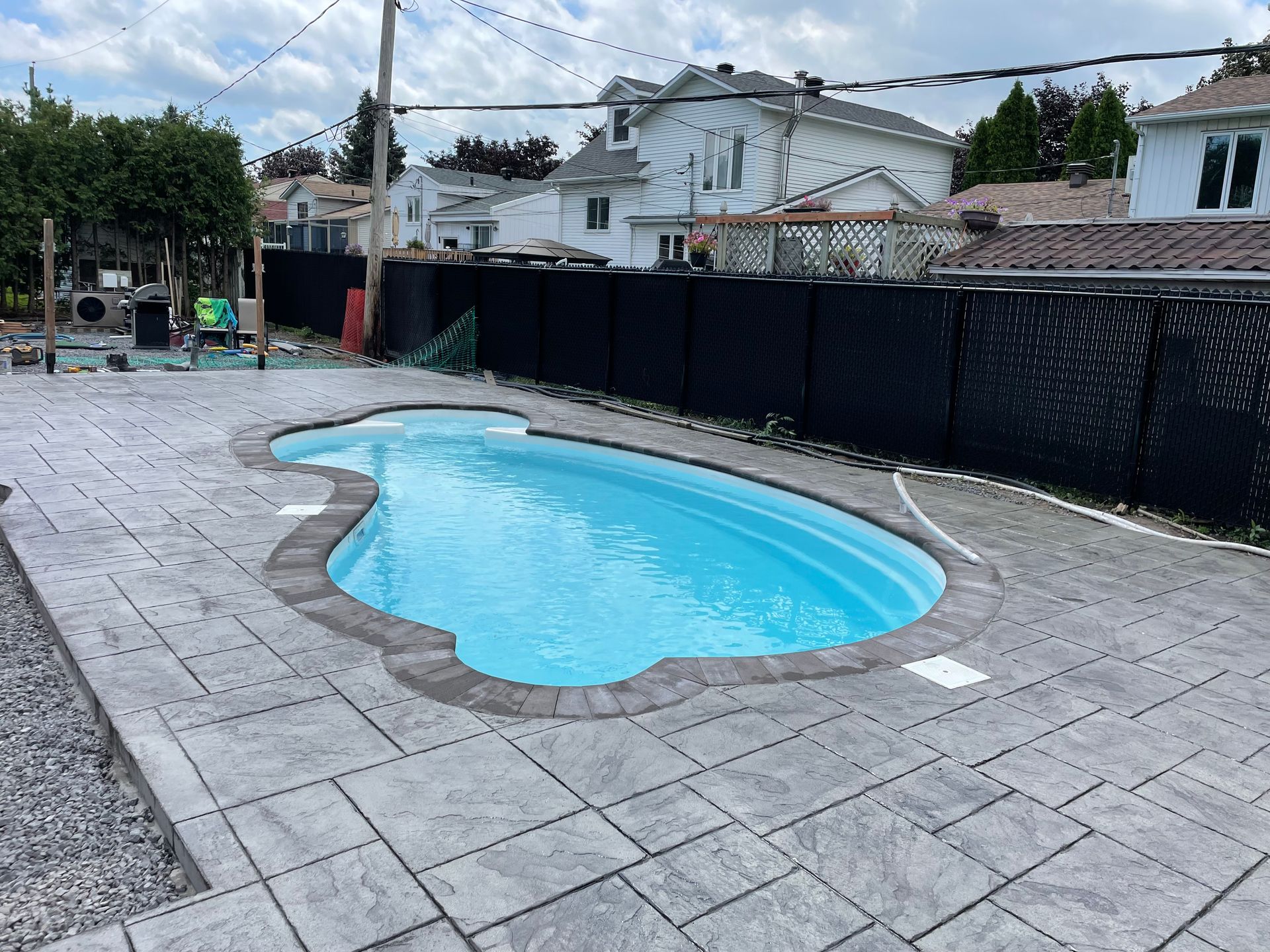 Une grande piscine se trouve dans l'arrière-cour d'une maison.