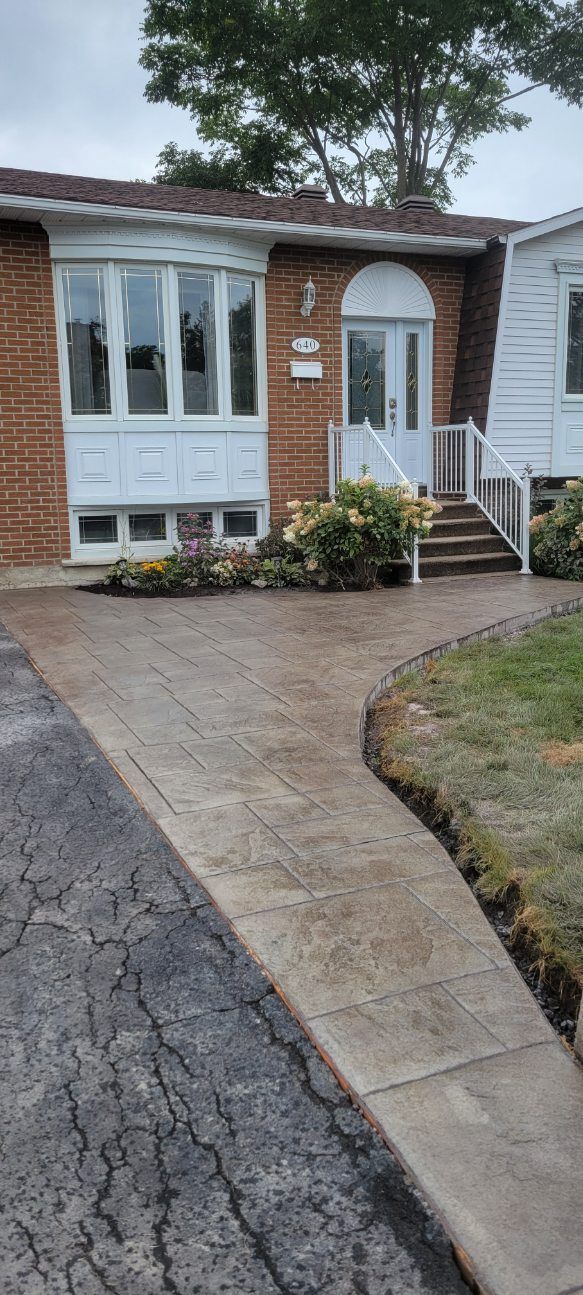 Une maison en brique avec une passerelle menant à la porte d'entrée.