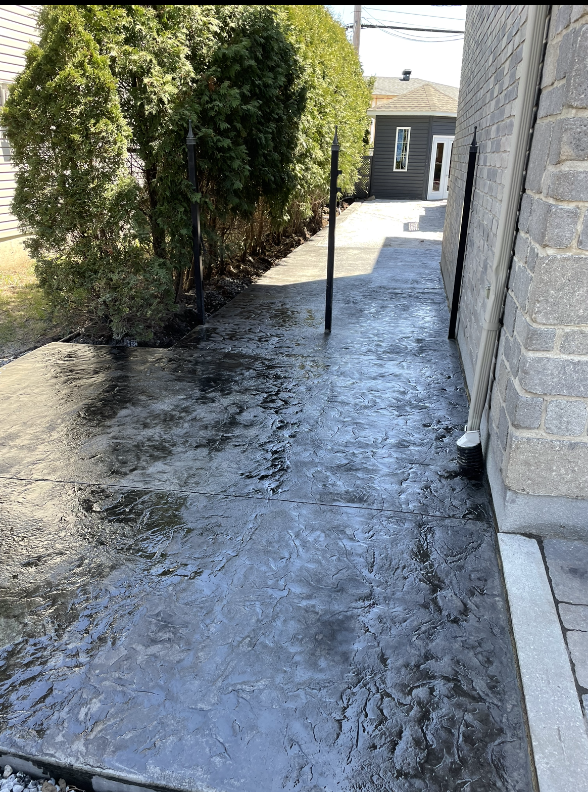 Une passerelle en béton menant à un bâtiment en briques avec des arbres en arrière-plan.
