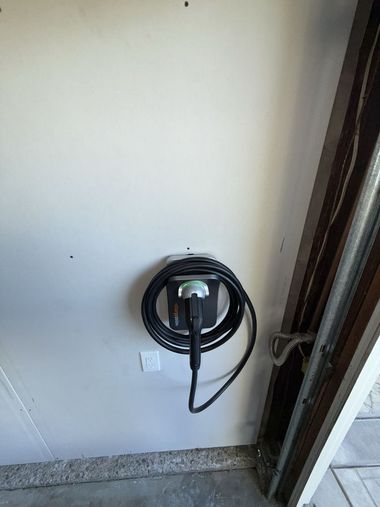 Brick house at dusk, lit walkway leading to front door, two people approaching.