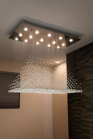 Electrician wearing a yellow hard hat and gloves working on a wall panel near a window.