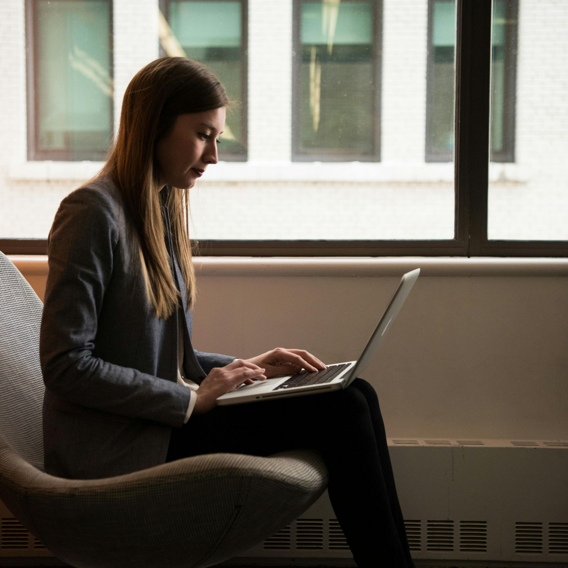 Kopje latte met latte art op een schoteltje en een lepel. 