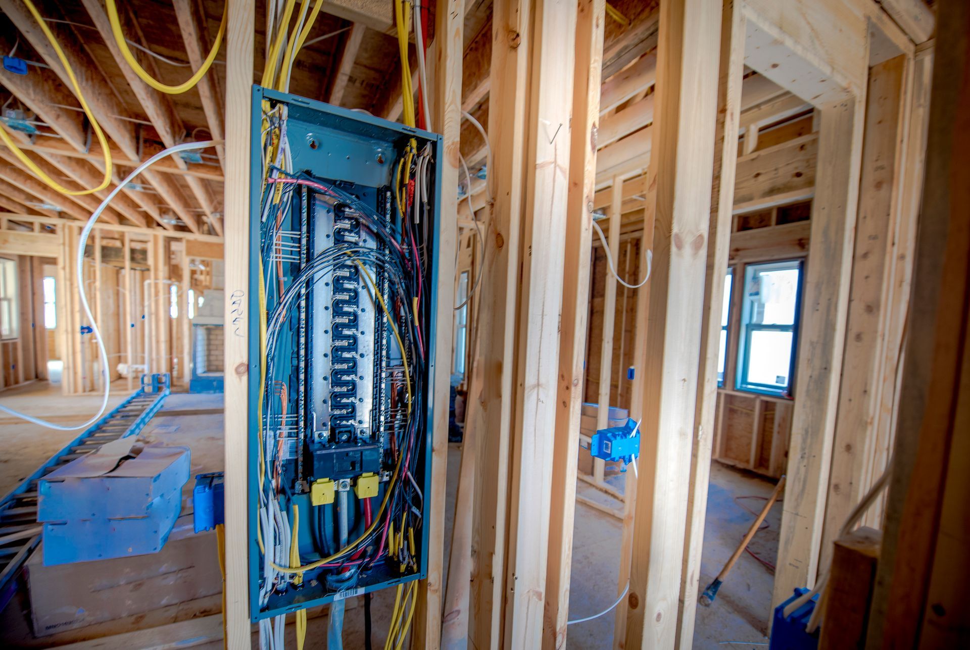 Person in yellow hard hat working on an electrical panel.