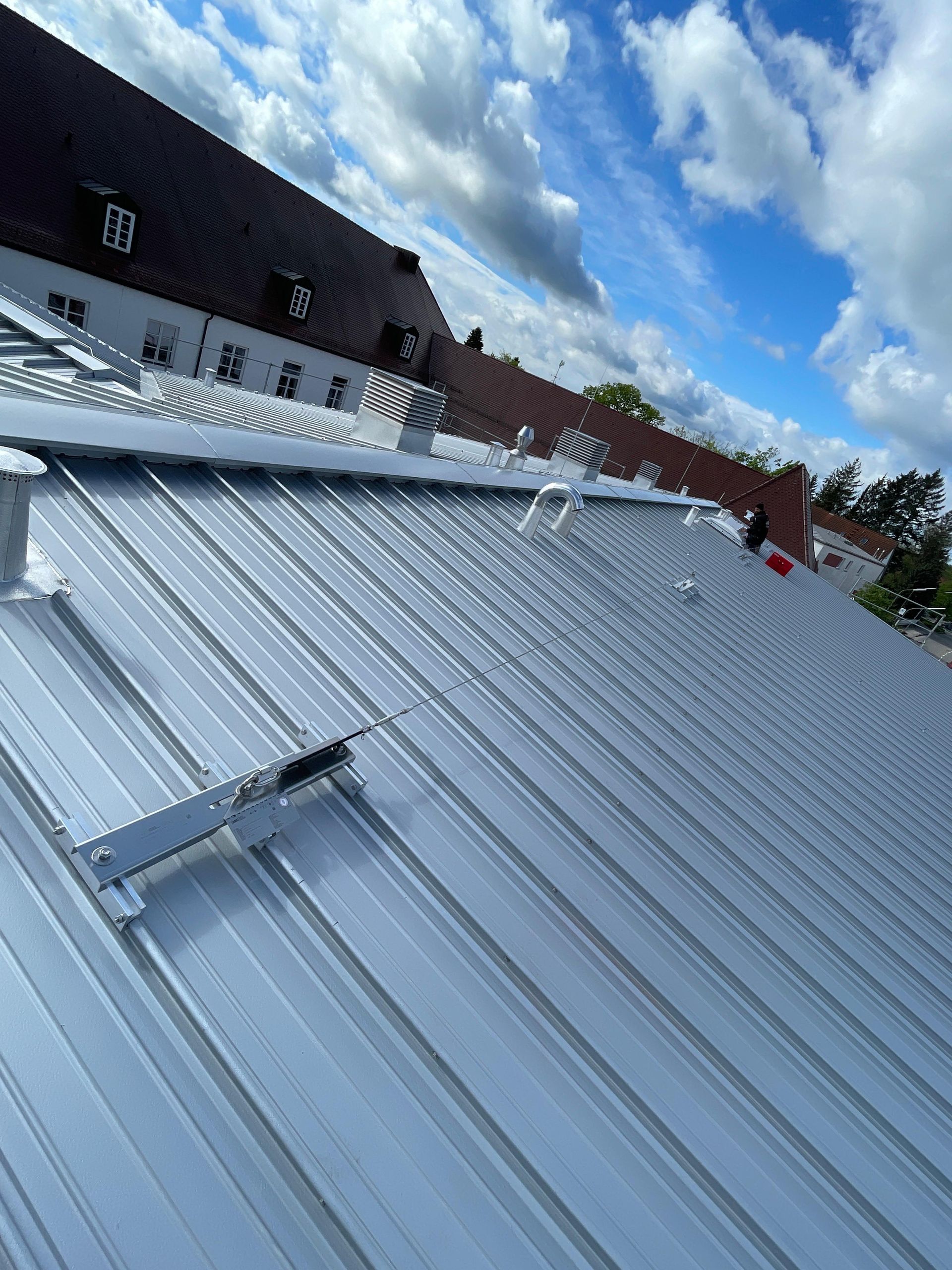 A close up of a metal roof with a blue sky in the background.