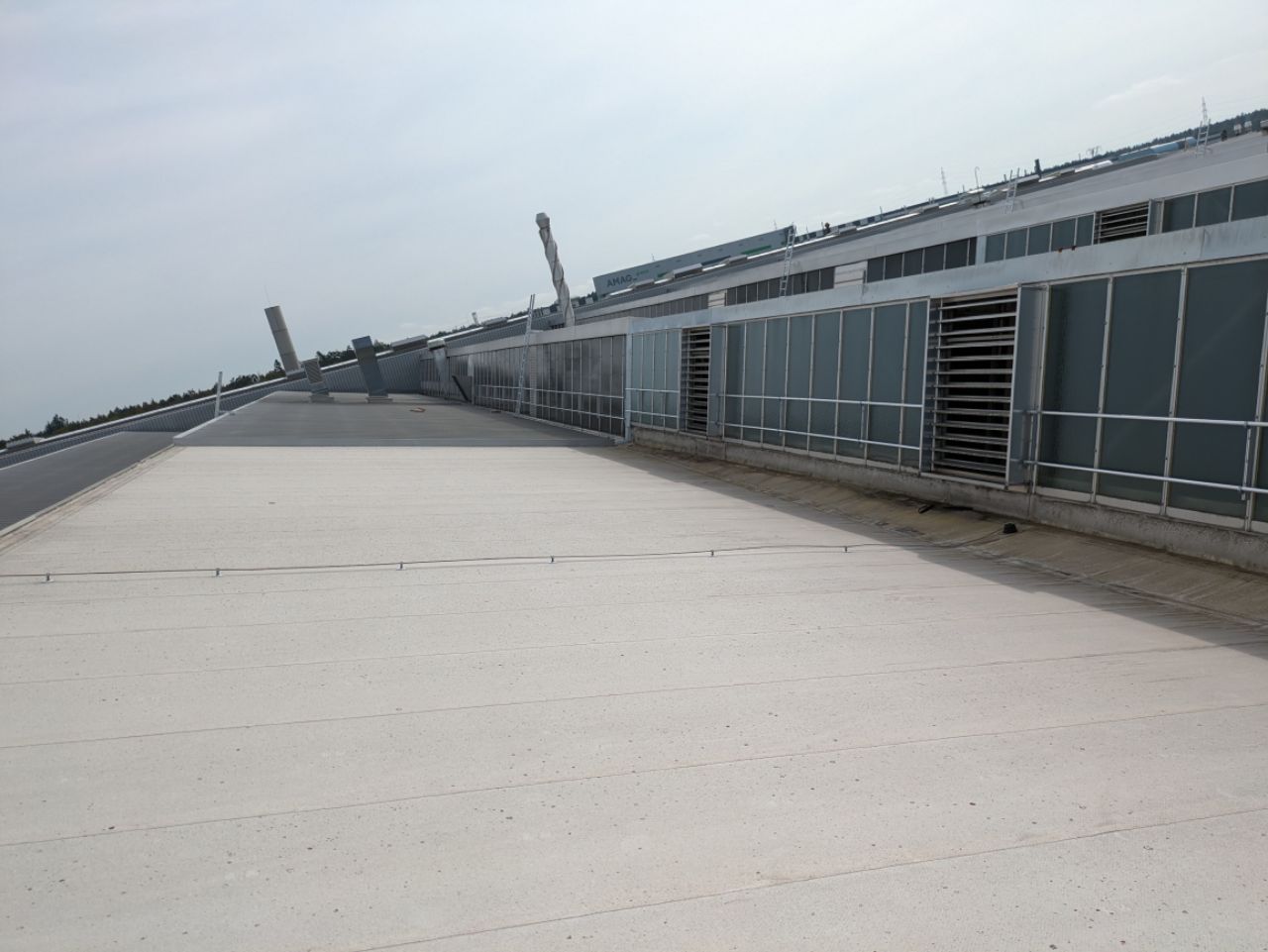 Ein großes Gebäude mit vielen Fenstern und einem weißen Dach.