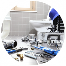 Plumbing tools, metal pipes, and fittings scattered on a tiled bathroom floor in front of a white toilet.