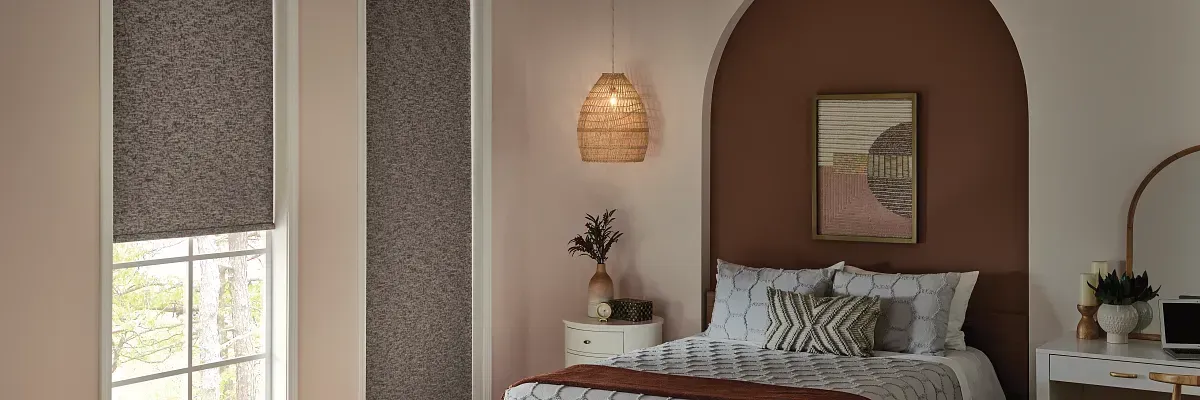 Beige room with shades and plants beside a bed