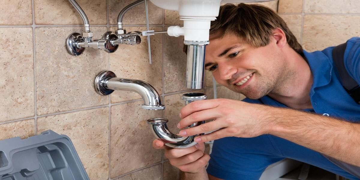 plumber installing sink in bathroom