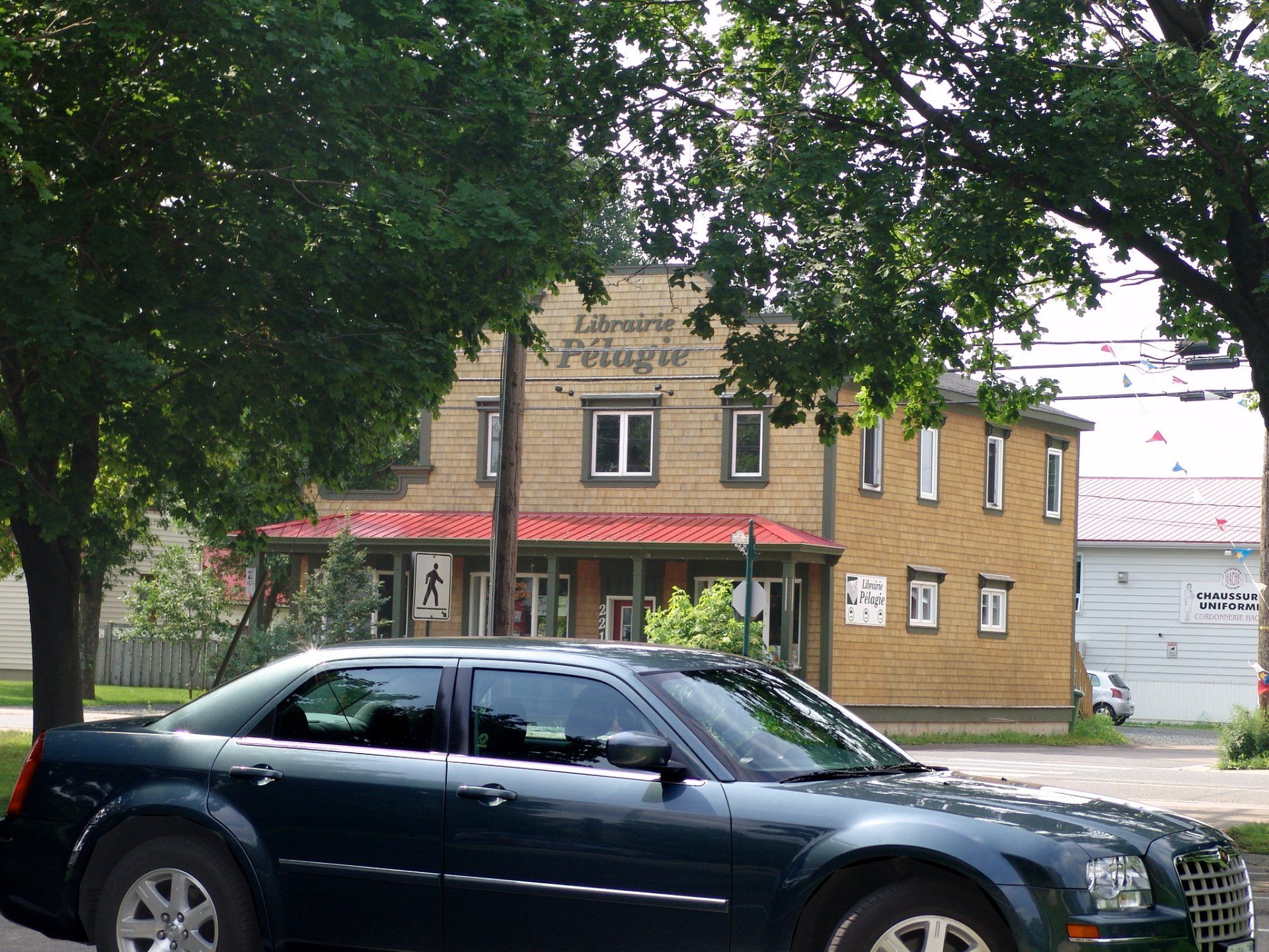 La voiture des hommes en noir devant la Librairie Plé;agie à Shippagan.