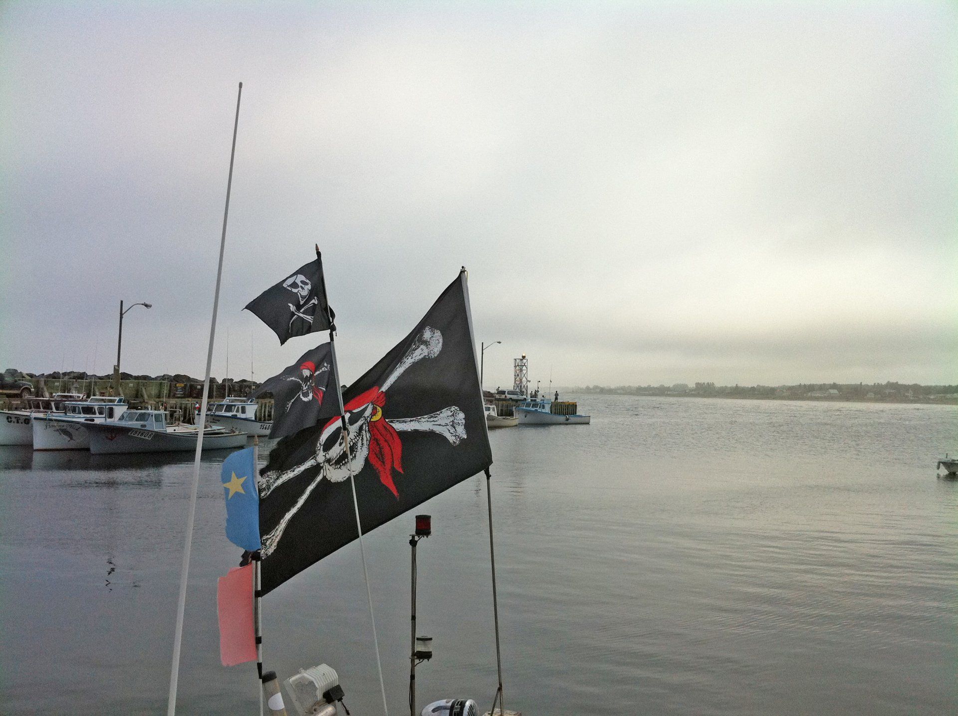 Un drapeau pirate avec une tête de mort et des os croisés dessus au quai de Petit-Rocher.