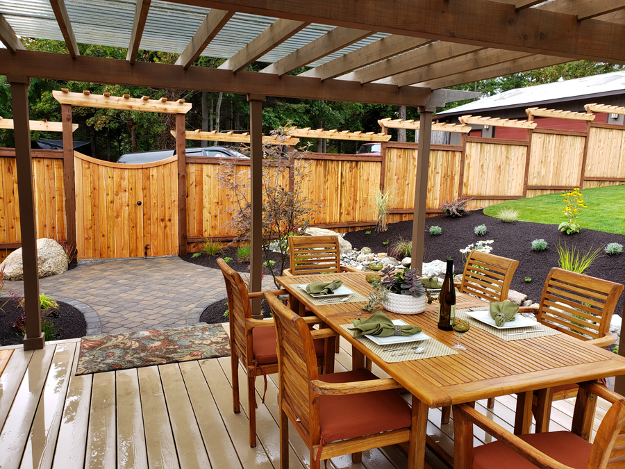 a wooden deck with a table and chairs under a pergola
