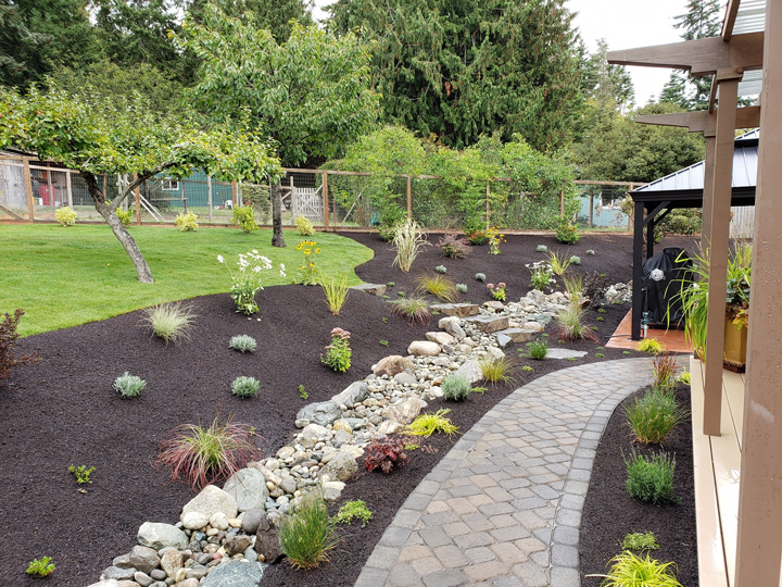 a walkway leading to a gazebo in a backyard