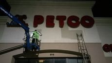Dublin CPS, Inc. tech, in lift, painting around store-front signage in Sandusky, Ohio.