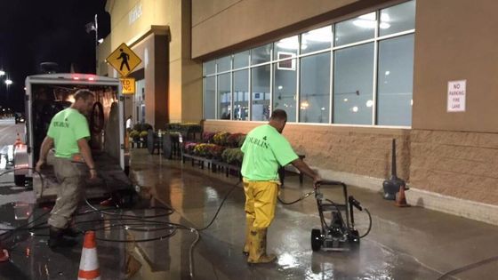 Dublin CPS, Inc. techs pressure washing the front walk of a store.