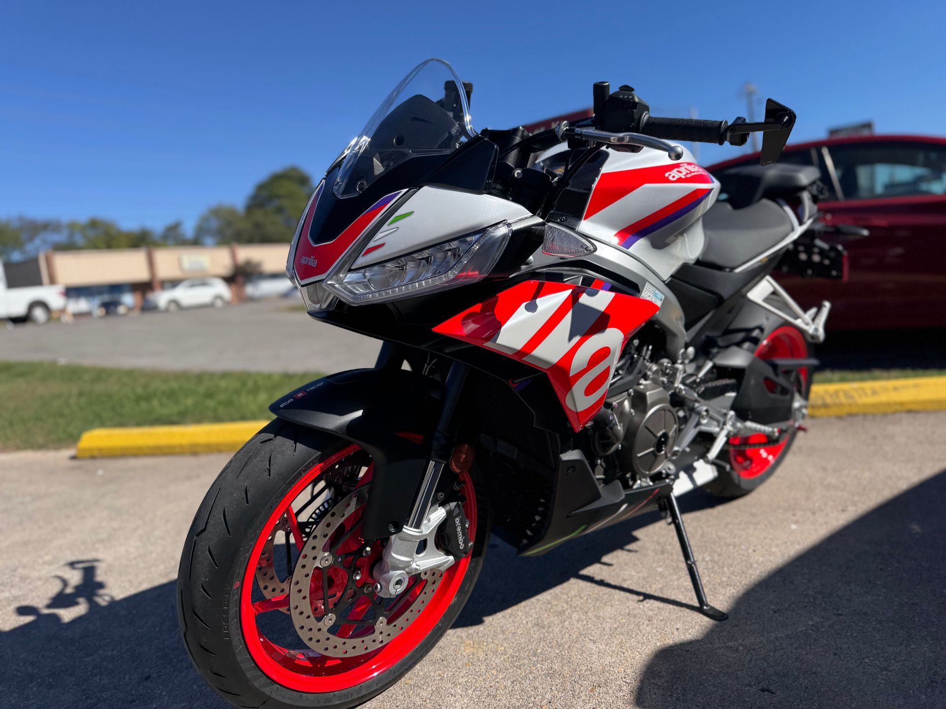 A red and white motorcycle is parked in a parking lot.